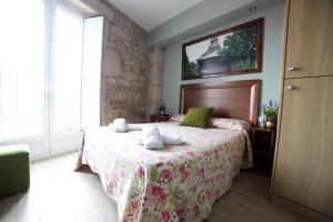 a bedroom with a bed with a floral bedspread at Pension Pardellas in Palas de Rei