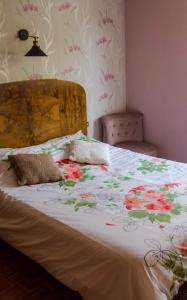 a bed with a floral comforter with two pillows on it at Chticabane in Taintrux