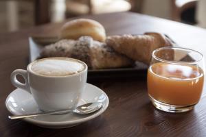 a cup of coffee and a plate of pastries on a table at Tra I Castelli in Filiano