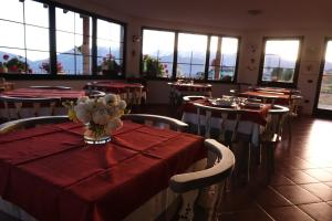 a restaurant with tables and chairs with red table cloth at La Capannina in Coredo