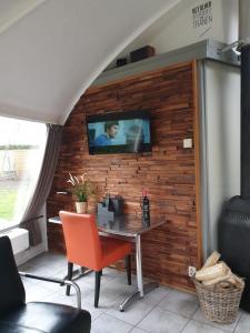 een kamer met een tafel en een tv aan de muur bij Iglo Bungalow 35 in Chaam