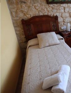 1 dormitorio con 1 cama con toallas en Pension Pardellas, en Palas de Rei 
