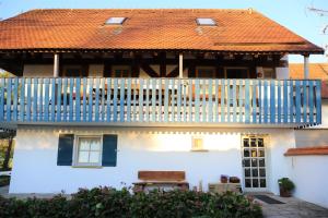 Casa blanca con barandilla azul y balcón en Gästehaus Roensch, en Frensdorf