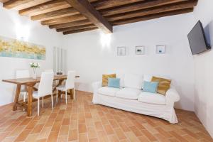 een woonkamer met een witte bank en een tafel bij Casa Vacanze Montefalco Il Borgo in Montefalco
