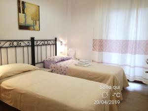 una camera da letto con due letti e una finestra di Apartment Conchiglie a Cala Gonone