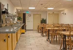 une salle à manger avec des tables et des chaises dans un restaurant dans l'établissement De Mallemoolen, à Amsterdam