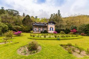 a large house in the middle of a garden at Casa da Lagoa in Furnas
