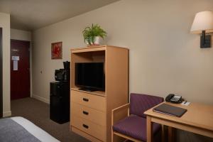 a hotel room with a bed and a desk and a tv at The Hotel Garibaldi in Garibaldi