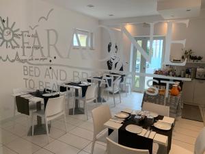 a restaurant with tables and chairs and a sign on the wall at B&B FARAONE in Martinsicuro