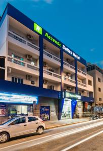 a car parked in front of a building at Rezende Suítes Hotel in Balneário Camboriú