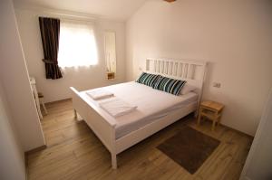 a bedroom with a white bed and a window at Mama Residence in Rovinjsko Selo