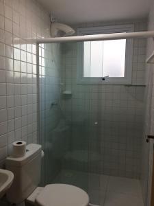 een badkamer met een douche, een toilet en een raam bij Apto Porto de Galinhas in Porto De Galinhas