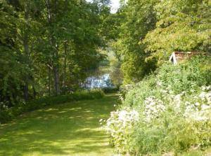 un terrain verdoyant avec des arbres et un chemin dans l'établissement Nordhagen Gate, à Hjo