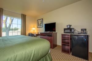 a hotel room with a bed and a flat screen tv at Cobblestone Inn & Suites - Linton in Linton