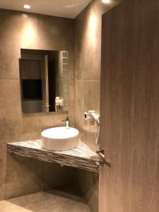 een badkamer met een wastafel en een spiegel bij Filoxenia Studios in Afitos
