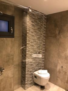 a bathroom with a sink and a toilet and a television at Filoxenia Studios in Afitos