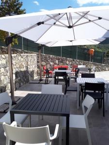 a patio with tables and chairs and an umbrella at ARIA Design B&B Levanto in Levanto