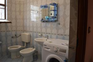 a bathroom with a toilet sink and a washing machine at Villa Ajla in Durrës +20 photos