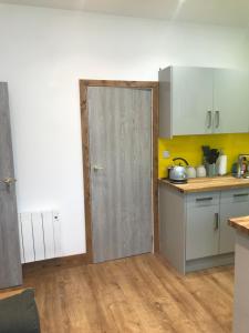 a kitchen with a door in the middle of a room at Nant Apartment - Ground Floor in Menai Bridge