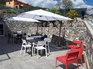a patio with tables and chairs and an umbrella at ARIA Design B&B Levanto in Levanto