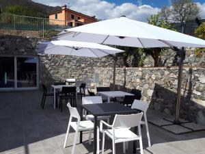 a patio with tables and chairs and an umbrella at ARIA Design B&B Levanto in Levanto