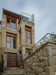 una casa de piedra con techo de cristal y escaleras en Casa do Outeiro, en Cangas de Morrazo
