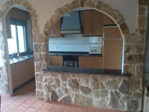 una cocina con un arco en una pared de piedra en Casa del Abuelo Ferrol, en Moaña
