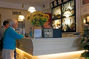 un homme se tenant à un registre de caisse dans un magasin dans l'établissement Hotel Prins Hendrik, à Amsterdam
