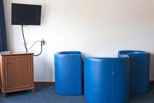 2 sillas azules en una habitación con TV en Hotel Prins Hendrik, en Ámsterdam