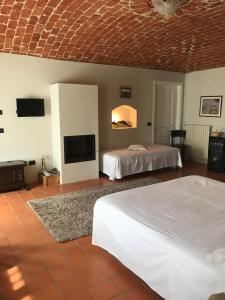 a hotel room with two beds and a tv at Sangrato 1883 in Monteu Roero