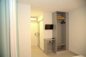 um quarto com um corredor com uma televisão e uma casa de banho em Hotel Cedran em Granada