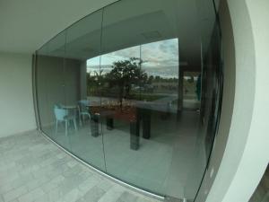 eine Spiegelreflexion mit einem Tisch und Stühlen in der Unterkunft Apto Porto de Galinhas in Porto De Galinhas