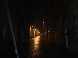 uma rua vazia à noite com luzes acesas em Hotel Pellegrino E Pace em Loreto