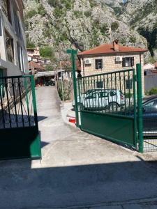 a green gate in front of a building at Viktor Rooms in Kotor