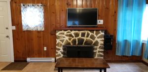 a living room with a fireplace with a tv above it at Malahat Bungalows Motel in Malahat