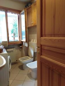 baño con aseo y lavabo y ventana en Breakfast in garden mountain view, en Calalzo