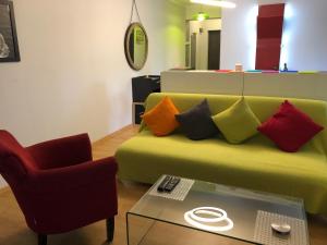 a living room with a green couch with colorful pillows at RELAX Cluj Apartment and Terrace in Cluj-Napoca