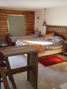 1 dormitorio con 1 cama y 1 mesa en una habitación en Cabañas Ranquil Luncay en Uspallata