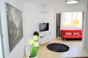 a living room with a red couch and a tv at Studio in The Center of Torremolinos in Torremolinos