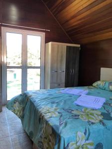 a bedroom with a bed with a blue comforter at Chale Premium Casal e Chale Charming Casal in Mairiporã