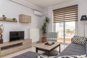 a living room with a couch and a tv at Sergios Apartments 13 in Alexandroupoli