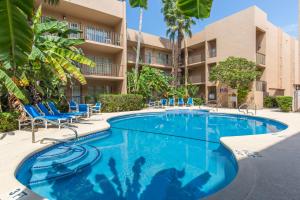 a swimming pool at a resort with chairs and a building at Beachview in South Padre Island