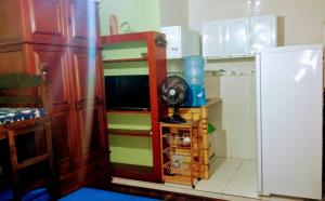 a kitchen with a fan on a shelf next to a refrigerator at Quitinete Cabo Frio , 300 metros da Praia do Forte in Cabo Frio