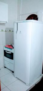 białą lodówkę w kuchni z kuchenką w obiekcie Quitinete Cabo Frio , 300 metros da Praia do Forte w mieście Cabo Frio