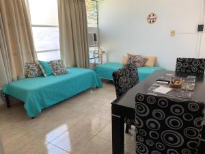 a living room with two beds and a table at Lo de ANNA in Posadas