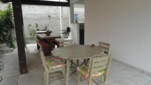 une table et des chaises en bois dans une chambre avec une table dans l'établissement Casa Praia de Taperapuan, Porto Seguro, à Porto Seguro