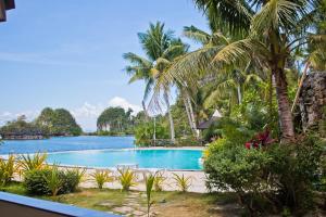 Caluwayan的住宿－Caluwayan Palm Island Resort & Restaurant，享有棕榈树游泳池的景色