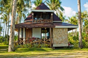 Caluwayan的住宿－Caluwayan Palm Island Resort & Restaurant，一座小房子,拥有门廊和棕榈树