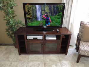 a flat screen tv sitting on a wooden entertainment center at Polo Beach Club in Wailea