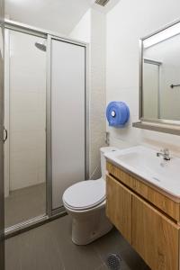 a bathroom with a toilet and a sink and a shower at 7 Wonders Hostel at Upper Dickson in Singapore
